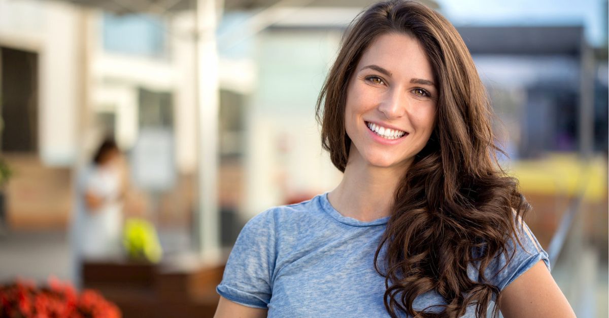 woman smiles after learning how to improve gum health quickly
