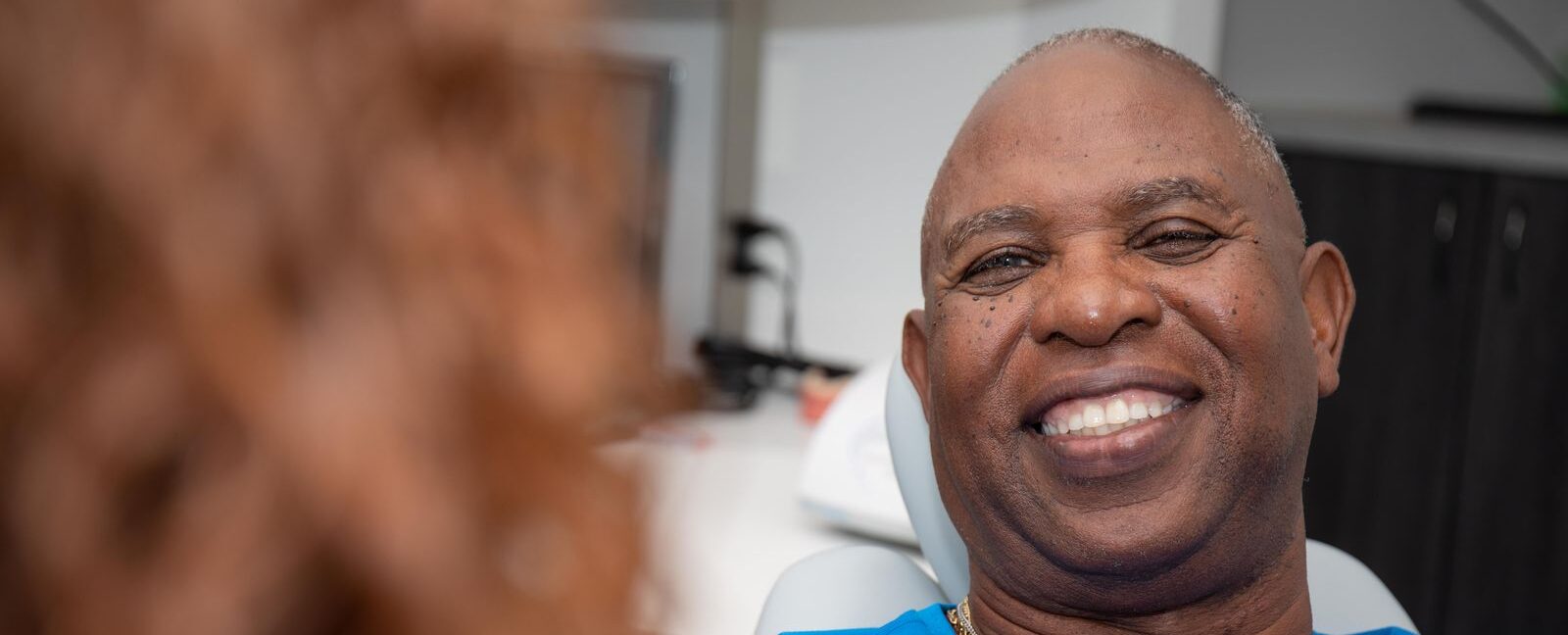 Smiling man undergoing periodontal treatment and examination.